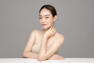 Beautiful young Asian woman model with perfect clean fresh skin on grey background. Face care,...
