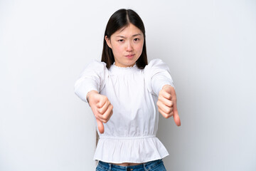 Young Chinese woman isolated on white background showing thumb down with two hands