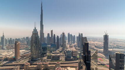 Aerial view of tallest towers in Dubai Downtown skyline and highway all day timelapse.