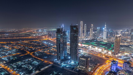 Dubai downtown with large-scale construction of a residential complex with cranes aerial night timelapse