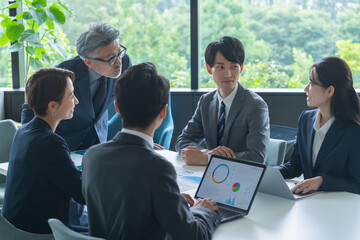 スーツを着た日本人男女の会議シーン