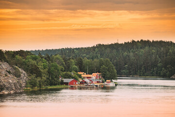 Sweden. Many Beautiful Red Swedish Wooden Log Cabins Houses On Rocky Island Coast In Summer...