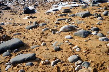 Close up of rocks on a sandy beach