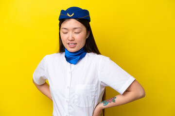 Airplane Chinese woman stewardess isolated on yellow background suffering from backache for having made an effort
