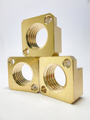 Brass metal body with golden light reflecting 3 pieces, stacked in a spiral inside. It is a machine part in the industry.