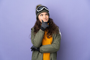 Teenager Russian girl with snowboarding glasses isolated on purple background and looking up