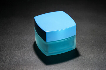 blue square cosmetic bottle in low light photo studio studio