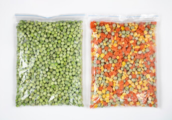 Mix of frozen vegetables in a package: carrots, corn grains, green peas on a white background, top...