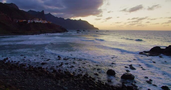 Twilight. Golden sunset over Atlantic Ocean, north Tenerife, Almaciga black sandy beach and village.