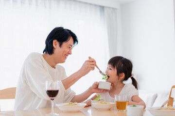 パパと一緒にご飯を食べる小さな女の子