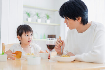 パパと一緒にご飯を食べる小さな女の子