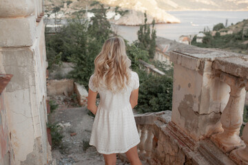 Fototapeta premium Beautiful woman in dress outdoor. Fashion female model walk in the street of old city view