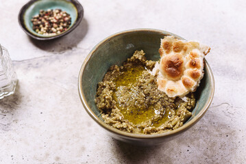 Babaganush or eggplant hummus from baked eggplant. Turkish eggplant dip baba ghanoush served with olive oil, pepper and oriental flatbreads. Selective focus