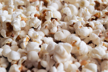 Heap of delicious popcorn isolated on white background. Scattered popcorn texture background. Selective focus.