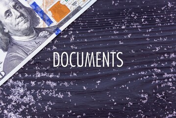 DOCUMENTS - word (text) on a dark wooden background, money, dollars and snow. Business concept (copy space).