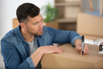 man writing on a parcel box