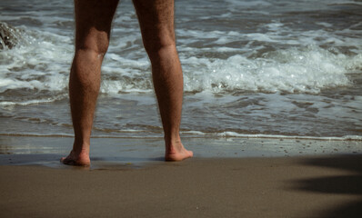 Adult man legs on beach