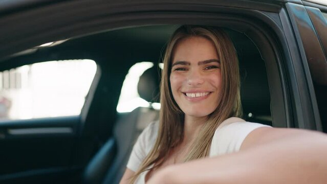 Young woman smiling confident driving car at street