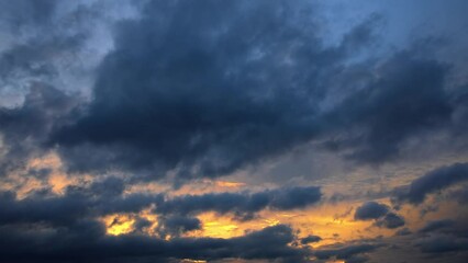 Black clouds and blue sky nature scenery at sunset. Colorful clouds move on the blue sky. 4k time lapse video.