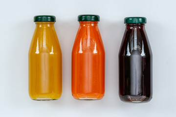 orange, pomegranate juice, bottled carrot juice, top view on white background, healthy eating concept, vitamin diet