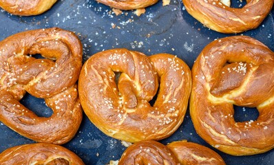 Handmade home stile delicious bagels cooked in the dark warm oven are prepare on the cooking paper at the farm kitchen using special form inside the hot oven. 