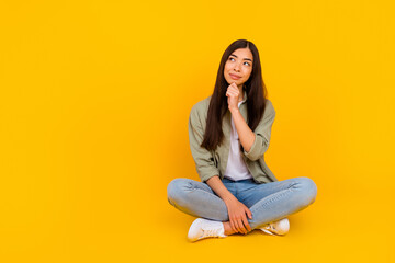 Full size photo of minded charming person hand touch chin look empty space isolated on yellow color...