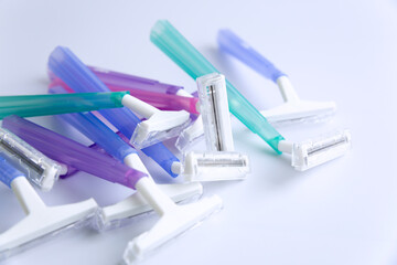 Set of multi-colored disposable razors on white background.