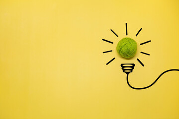 Creative thinking ideas and innovation concept. A ball of green threads with a light bulb symbol on...