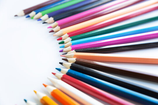 Set of colored watercolor pencils arranged in a semicircle isolated on a white background.