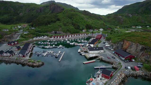 Aerial backwards shot of a Norwegian marina harbor in Helgeland, Tonnes, clouds reflecting on the surface