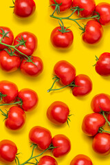 Tomato on a branch sprout top view flatlay on a yellow background. Fresh juicy ripe tomato Red Cherry fruits. Salad preparation ingredients