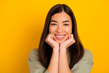 Portrait of young stunning asian girl lean her chin on her hands relaxing on weekend day isolated on yellow color background