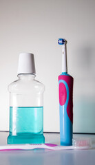 Electric toothbrush and mouthwash on white background