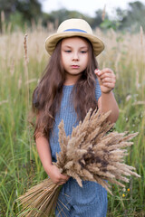  Cute girl in a hat in a field. Kid girl 4-5 year old wearing  hat  outdoors.
