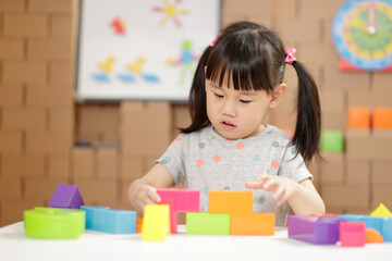  young girl playing creative toy blocks for homeschooling