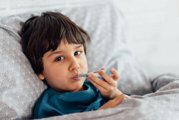Child flu sick, boy with medical thermometer in mouth, health illness. Kid with cold rhinitis, get...