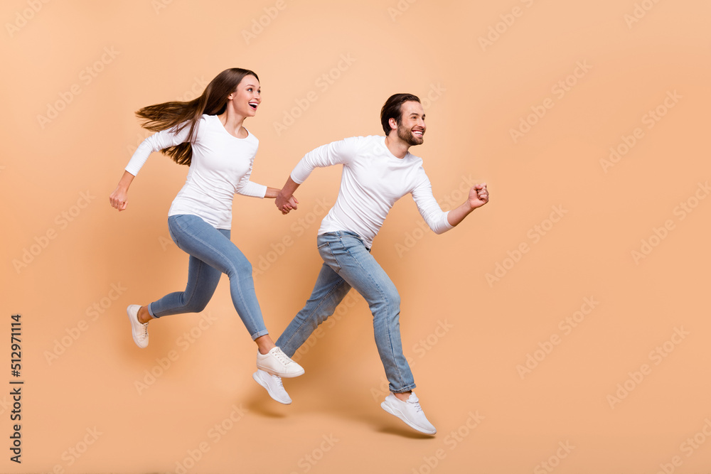 Poster full length body size view of attractive trendy cheerful partners jumping motion run isolated over b