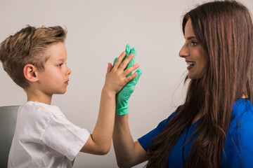 Cheerful great dentist giving his little patient a high five