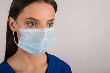 portrait of young female doctor in medical mask looking at left.