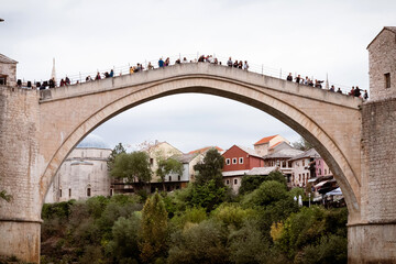 Fototapeta na wymiar The historic town of Mostar, spanning a deep valley of the Neretva River, is famous for Old Bridge, Stari Most. The Ottoman architecture is protected by UNESCO
