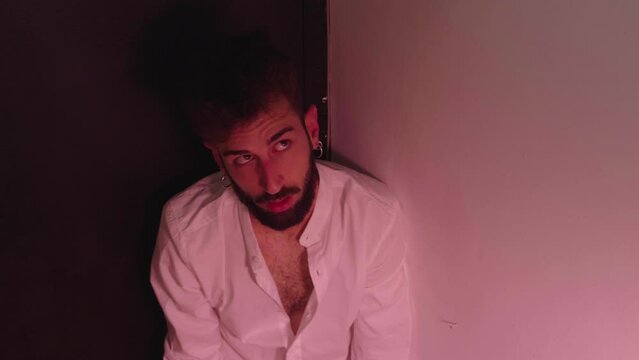 young man brutalized by alcohol stares at the ceiling with a catatonic gaze