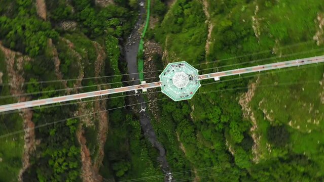 Dashbashi, Georgia - 19th june, 2022: Aerial circle over Diamond cafe on glass bridge over scenic dashbashi valley in Georgia countryside. Famous modern bridge over valley