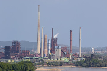 Close up of a blast furnace and coking plant next to the Rhine, seen from the Halde Rheinpreussen near Duisburg. The landscape behind the plant is blurred due to the heat radiation from the plant.