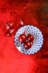 Spanish onion on blue ceramic plate. Vibrant background with copy space. Food still life photo. 