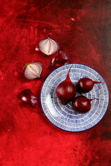 Spanish onion on blue ceramic plate. Vibrant background with copy space. Food still life photo. 