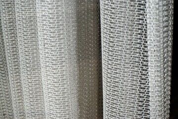 Weiße alte Gardinen hinter Glasscheibe von Fester mit Falten und Muster 