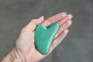 Green guasha scraper is good for skin care anti-aging.