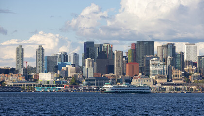 Fototapeta premium Downtown Seattle, Washington, United States of America. Panoramic View of the Modern City and Ferry Boat on the Pacific Ocean Coast. Cloudy Blue Sky.