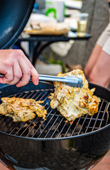 Hand of young man chef grilling some meat outdoor