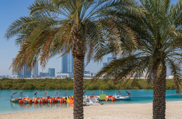 Al Reem Central park in Abu Dhabi with two plam trees and leisure activities